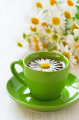 Herbal chamomile tea in a green cup