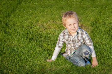 Little blond boy on the grass