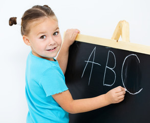 Little girl is showing letter E on the alphabet