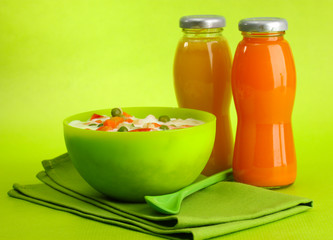tasty  dieting food and bottles of juice, on green background