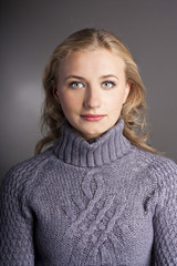 Portrait of a blonde in a sweater. studio