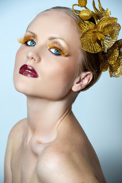 Woman With Gold Make Up And Gold Orchid In Hair