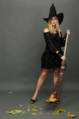 Halloween witch with  broom on gray background