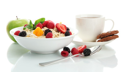 tasty oatmeal with berries and cup of tea, isolated on white