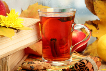 cup of hot tea and autumn leaves, on wooden table