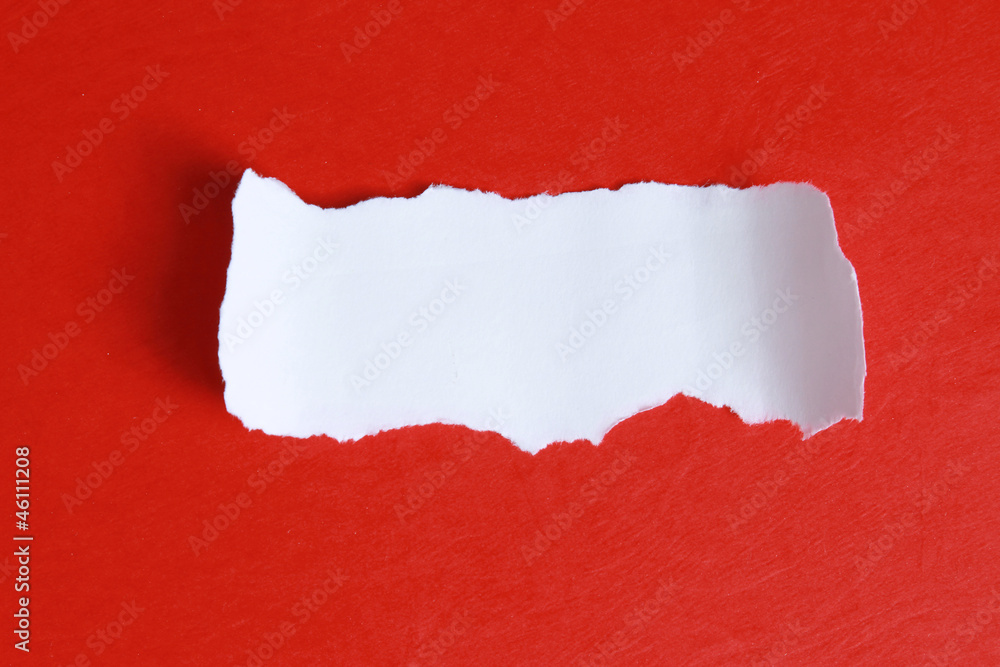 Fototapete close-up view of torn piece of paper for ô message on red