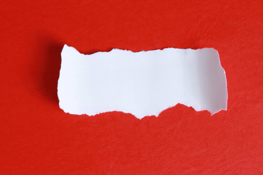 Close-up view of torn piece of paper for ô message on red