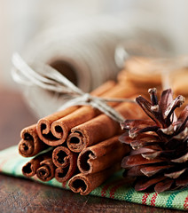 Close up of cinnamon sticks and cone on tea towel
