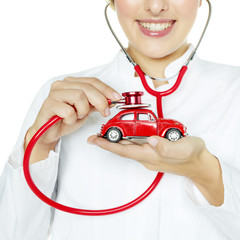 Woman is checking a red car very closely with stethoscope