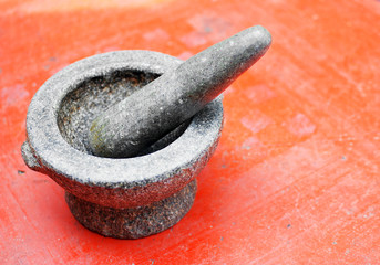 Stone mortar on red background