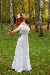 red-haired young woman head looking up, arms as if flying