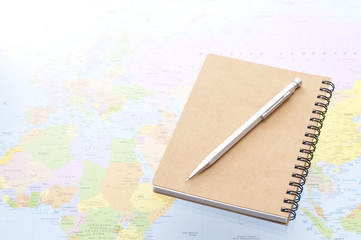 地図の上のノートとペン