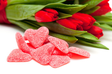 heart-shaped candies and red tulips