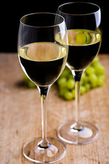 White wine with grapes on wood table