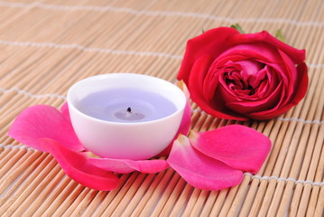 Fototapeta na wymiar rose and a candle on a bamboo place mat