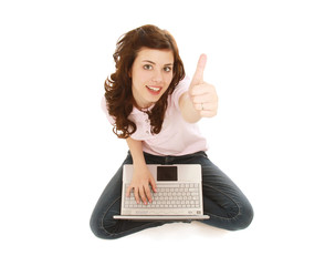 A young girl with a laptop sitting on the floor, showing ok