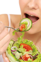 A woman is eating a salad - close-up image