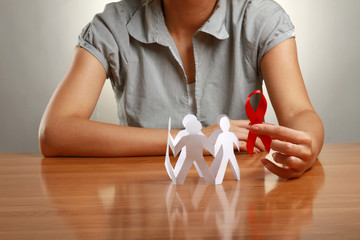 Female hands holding paper people and a red