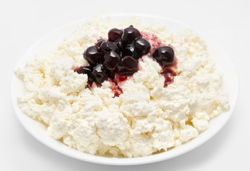 Fresh cottage cheese in the bowl with cherry jam isolated