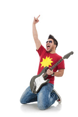 guitarist on his knees rock sign