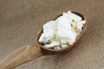 Fresh cottage cheese in a large wooden spoon