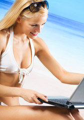 Woman with laptop on beach