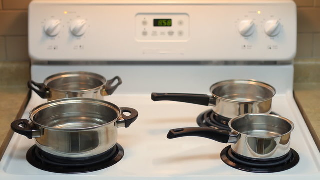 Four pots full of boiling water on the stove. Accelerated motion