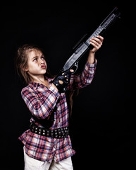 Fototapeta premium Portrait of beautiful girl posing in studio with gun