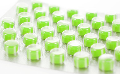 green pills isolated on white