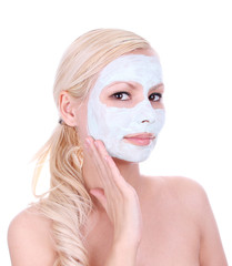 beautiful blonde girl applying clay mask on face isolated