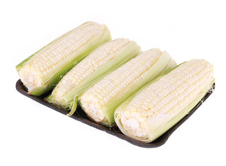 four white corn on black plate isolated on white