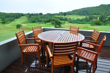Chairs and table on wooden in a Green grass on a golf field