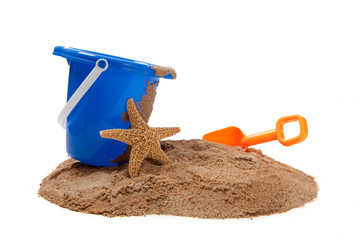 A blue pail and orange shovel with a starfish on the beach