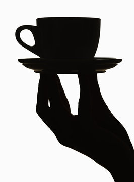 Silhouette of hand holding a coffecup