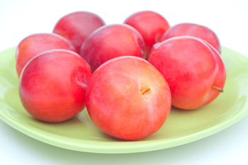 Ripe red plums on plate