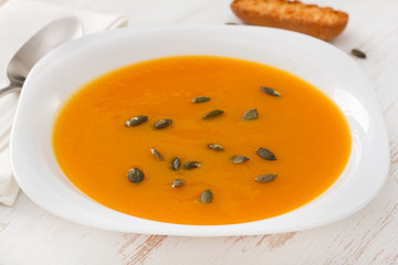 pumpkin soup in plate with spoon