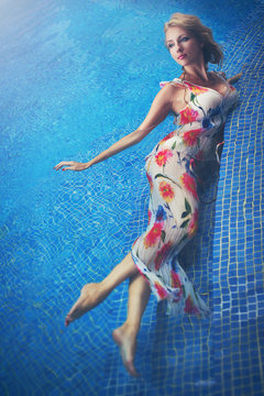 Young blonde woman in the swimming pool, fashion portrait.