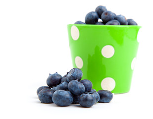fresh blueberry in a green mug over a white background.