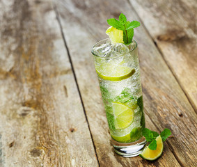 Mojito with a slice of lime on a wooden table