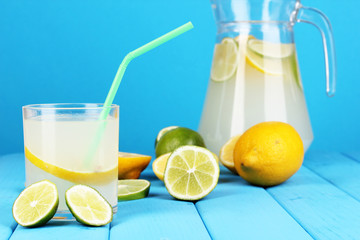 Citrus lemonade in pitcher and glass of citrus around