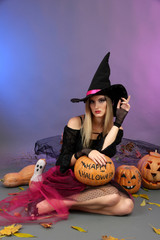 Halloween witch holding pumpkin on color background