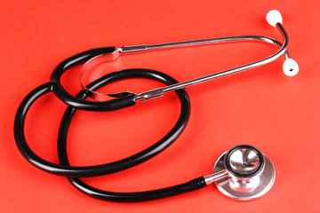 Stethoscope on red background