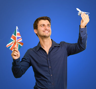 Man holding flag and miniature of airplane