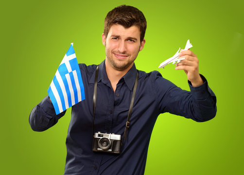 Man Holding A Miniature Airplane And Greece Flag