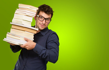 Young Man Holding Stack Of Books