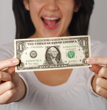 Joven mujer sujetando un billete de un d&oacute;lar.