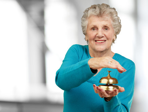 Happy Mature Woman While Holding Bell