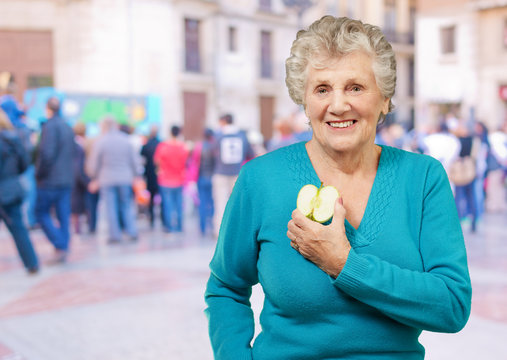 Portrait Of Happy Mature Woman While Holding Apple