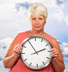 Senior Woman Holding A Clock