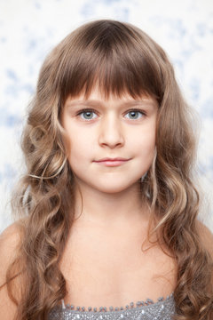 Portrait of sincere young grey-eyed girl child looking at camera